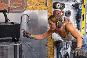 Fenokee co-founder Annie McElree checks on a steel rod heating up in the forge in her and Mr. Hart’s workshop Sept. 26, 2025. CREDIT ANNIE SMITH BARKALOW