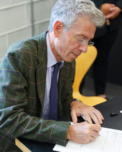 Cornell College President Jonathan Brand signs the transfer of ownership form.