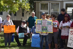 Residents of manufactured home parks owned by Havenpark Communities, along with advocates, hold signs during a press conference Oct. 1, 2025.