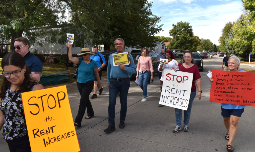 Residents of Havenpark Communities' manufactured home parks in Johnson County, along with supporters, walk to the manager's office at Modern Manor.