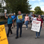 Residents of Havenpark Communities' manufactured home parks in Johnson County, along with supporters, walk to the manager's office at Modern Manor.