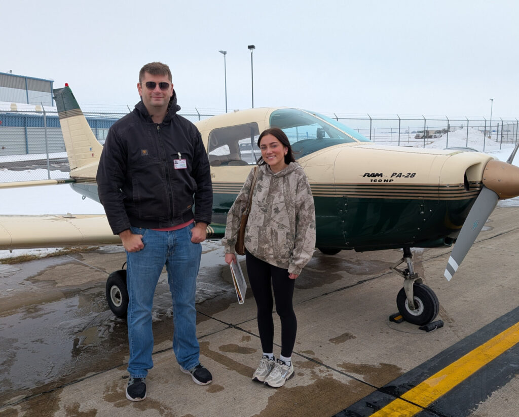 Luke Hewitt, instructor with Coe College's aviation management and flight operations program, stands next to Addy LuGrain, the first of three aviation students in the program's history to complete a solo flight.