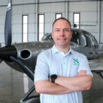Executive Aero Club founder Matthew Gunderson stands with one of the club’s Cirrus SR Series G7 Plus planes at the company’s hangar at Signature Aviation in Cedar Rapids. CREDIT Richard Pratt