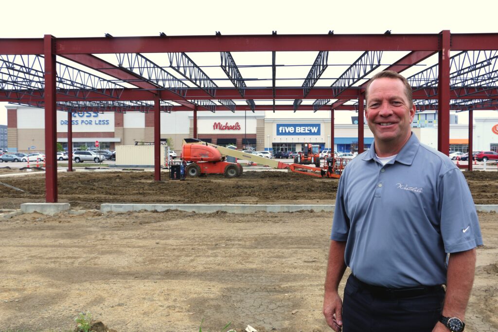 Todd Nelson, president and CEO of Frew Development Group’s Midwest Division, stands next to Westdale Town Center’s newest building, which will house Bath and Body Works and other retailers. CREDIT RICHARD PRATT