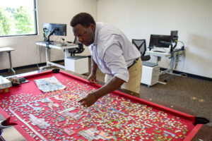 Trevor Bollers works on a puzzle in his office. CREDIT ANNIE SMITH BARKALOW